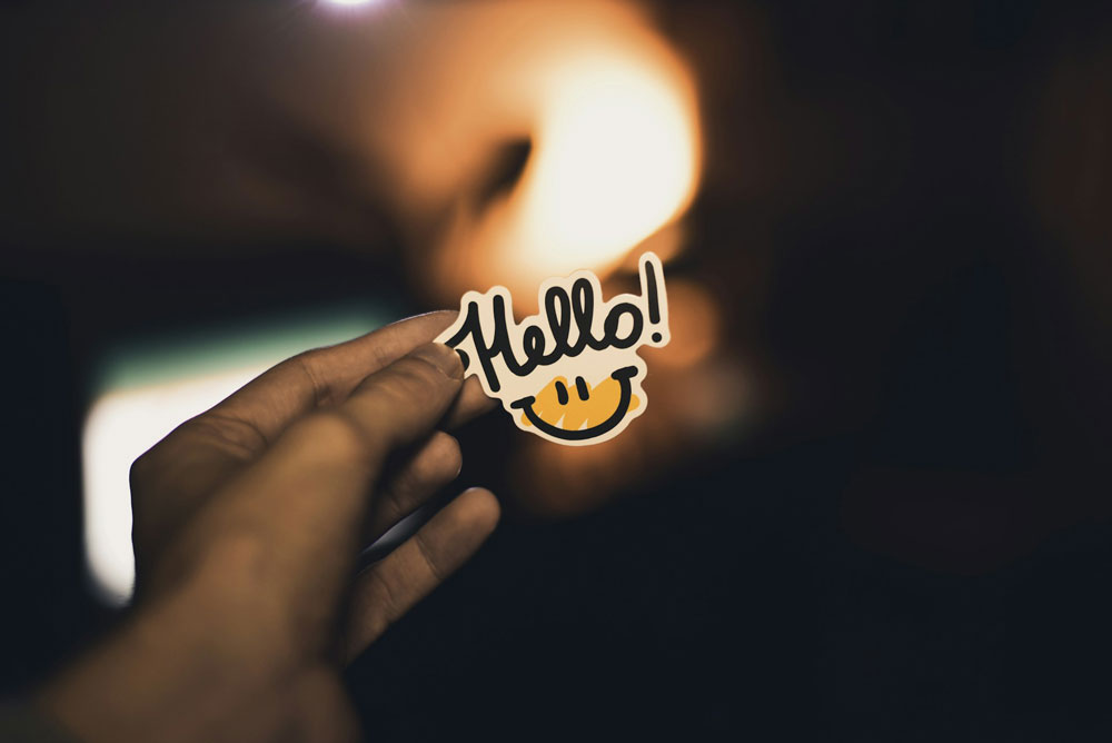Holding up a sign that says hello.